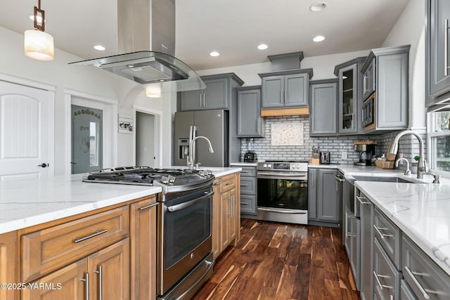 921 Tibbling Rd, Selah, WA 98942 - kitchen featuring appliances with stainless steel finishes, island exhaust hood, gray cabinetry, dark wood-style flooring, and light stone countertops