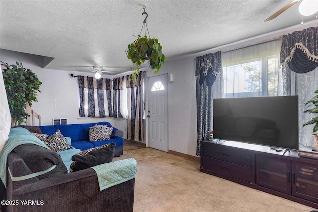 living area featuring a textured ceiling, ceiling fan, light colored carpet, and visible vents