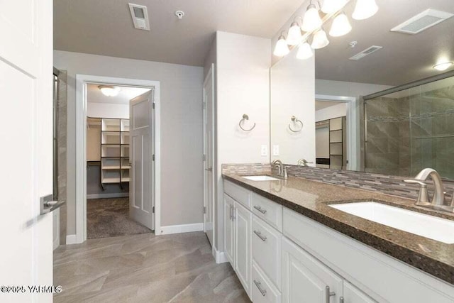 8905 Occidental Rd Unit 202A, Yakima, WA 98903 - bathroom with double vanity, a spacious closet, a shower stall, and baseboards