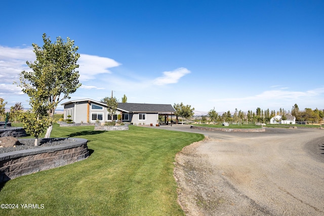 view of front of property with driveway, a front lawn, and a carport