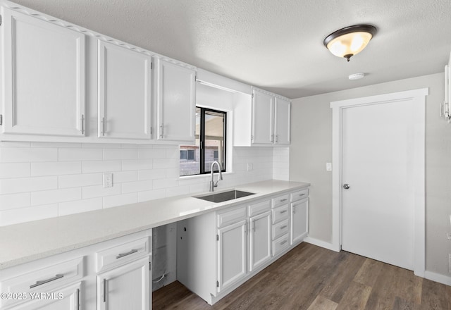 kitchen featuring dark wood-style floors, a sink, and a textured ceiling