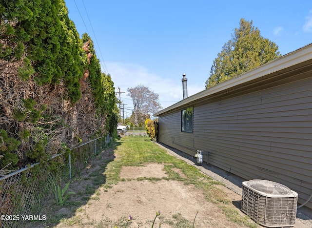 view of side of property featuring central AC and fence