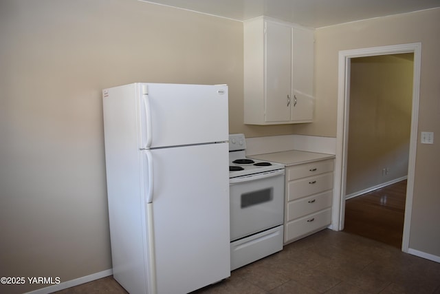 kitchen with white cabinets, white appliances, light countertops, and baseboards