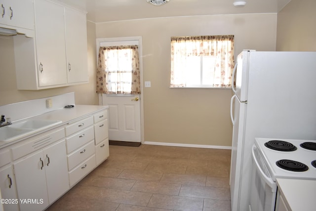 kitchen featuring a sink, white cabinetry, white appliances, light countertops, and baseboards