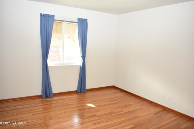 empty room with light wood-style floors and baseboards