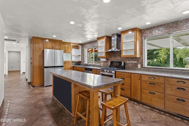 5252 US Highway 12, Yakima, WA 98908 - kitchen featuring stainless steel appliances, wall chimney range hood, brown cabinets, a kitchen island, and open shelves