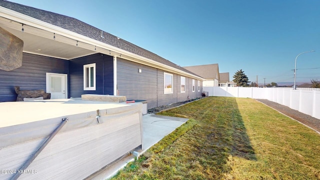 view of side of property featuring a fenced backyard, a yard, and a patio