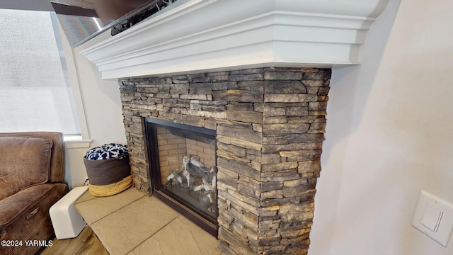 interior details featuring wood finished floors and a stone fireplace