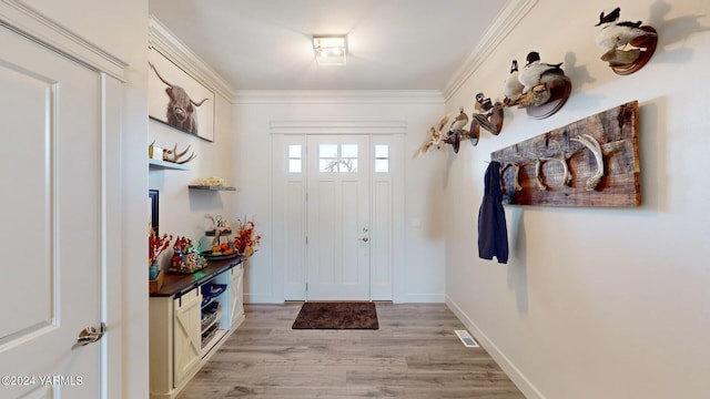 mudroom with light wood finished floors, baseboards, visible vents, and ornamental molding