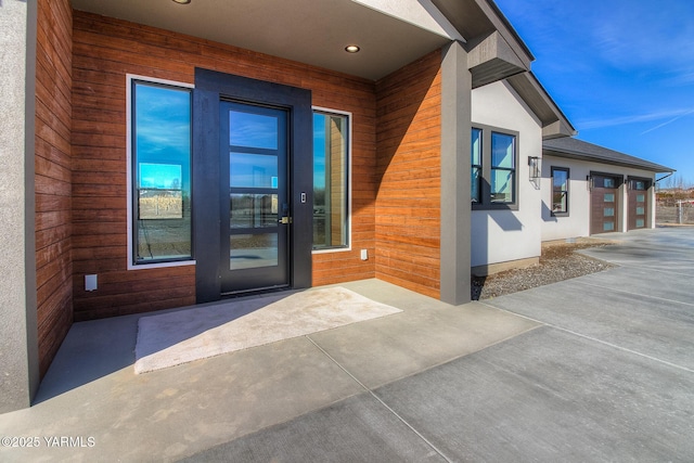 doorway to property featuring a patio and stucco siding