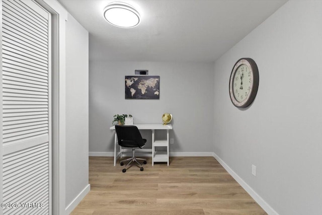 office area with light wood finished floors and baseboards