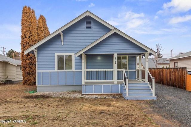 view of front of home featuring a porch and fence