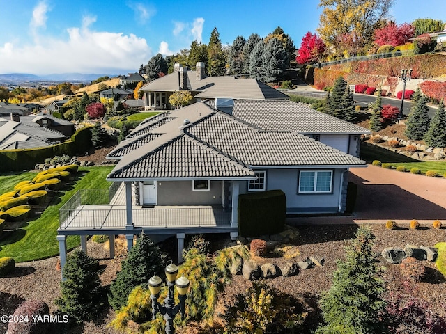 exterior space featuring a wooden deck, a tile roof, a residential view, and stucco siding