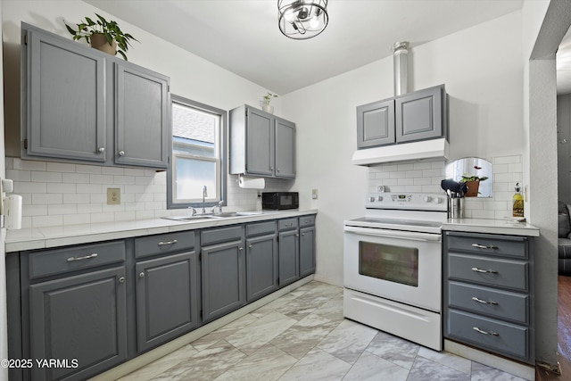 708 S 8th St, Yakima, WA 98901 - kitchen featuring electric stove, under cabinet range hood, light marble finish floors, and gray cabinets
