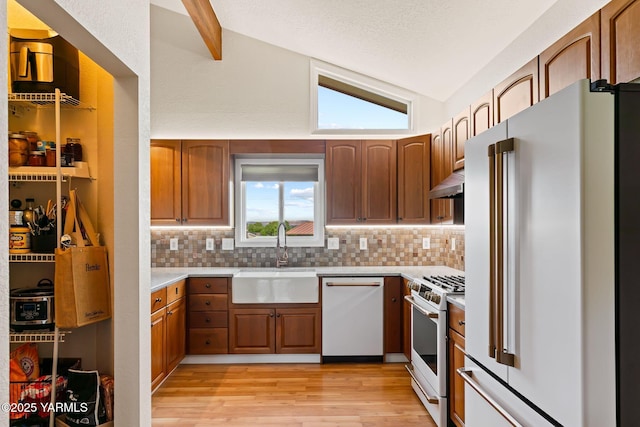1312 Dazet Rd, Yakima, WA 98908 - kitchen with white appliances, a sink, light countertops, under cabinet range hood, and lofted ceiling