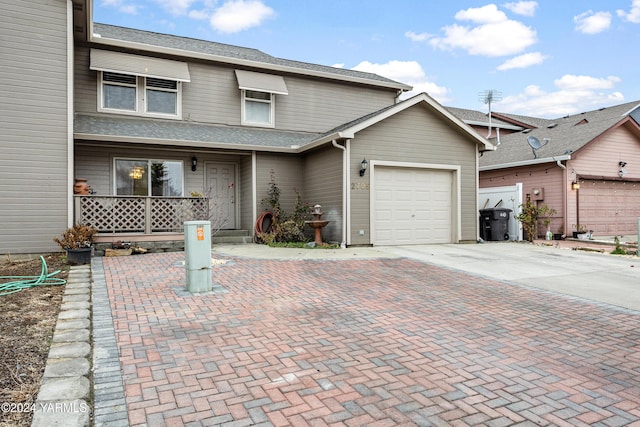 view of property with decorative driveway and an attached garage