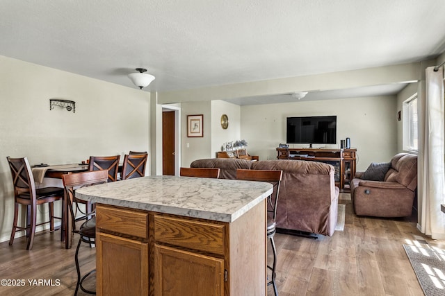 5502 Bristol Way, Yakima, WA 98908 - kitchen featuring wood finished floors, a breakfast bar, open floor plan, a center island, and light countertops