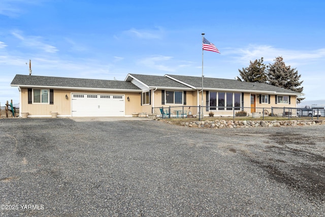 ranch-style house with driveway, a garage, and fence