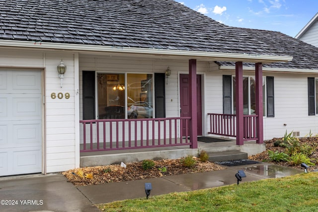 property entrance with an attached garage and covered porch