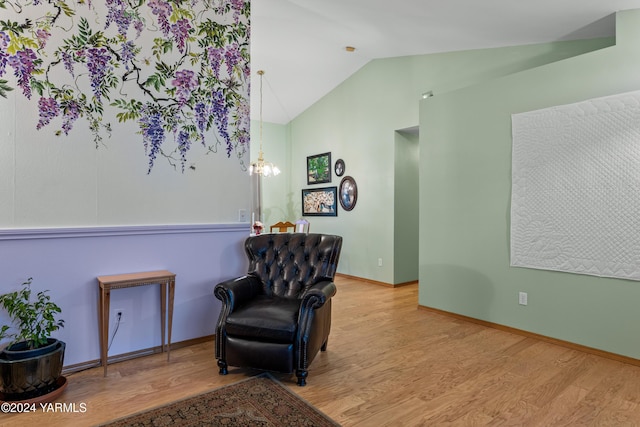 sitting room featuring light wood-style flooring, baseboards, and vaulted ceiling