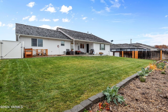 back of property with a patio, a fenced backyard, a gate, a yard, and central AC
