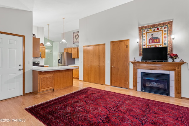 609 Jade Pl, Yakima, WA 98908 - kitchen featuring appliances with stainless steel finishes, light wood-type flooring, light countertops, a peninsula, and a towering ceiling