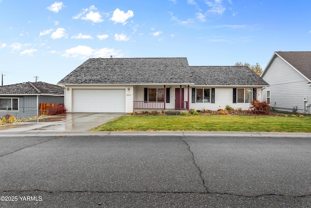 view of front of home featuring covered porch, concrete driveway, a front lawn, and a garage