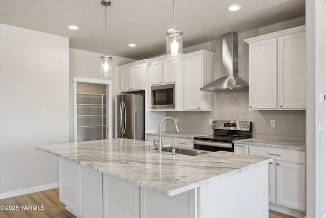 172004 NW Dogwood Rd, Prosser, WA 99350 - kitchen featuring wall chimney range hood, stainless steel appliances, a sink, white cabinetry, and recessed lighting