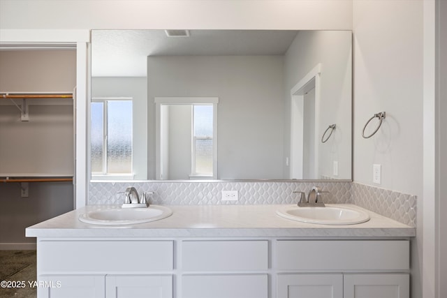 172004 NW Dogwood Rd, Prosser, WA 99350 - bathroom featuring double vanity, backsplash, and a spacious closet