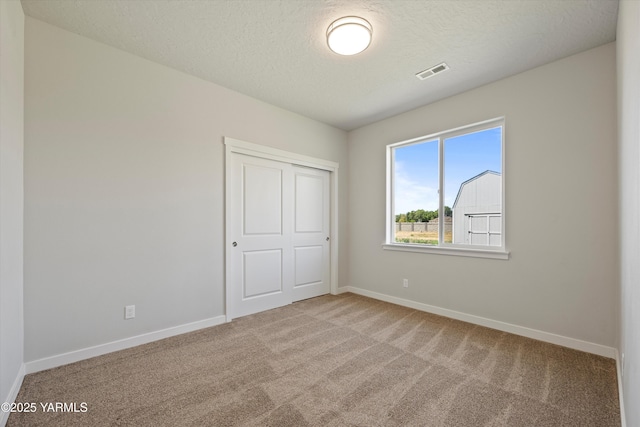 172004 NW Dogwood Rd, Prosser, WA 99350 - unfurnished bedroom featuring carpet flooring, baseboards, a textured ceiling, and a closet