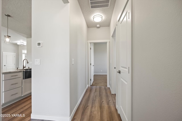 172004 NW Dogwood Rd, Prosser, WA 99350 - corridor with a textured ceiling, dark wood-type flooring, and baseboards