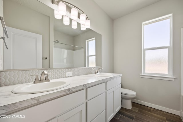 172004 NW Dogwood Rd, Prosser, WA 99350 - bathroom with double vanity, a shower, baseboards, wood finished floors, and toilet