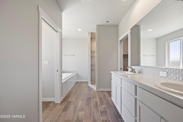 172004 NW Dogwood Rd, Prosser, WA 99350 - full bathroom featuring a bath, a textured ceiling, double vanity, decorative backsplash, and wood finished floors