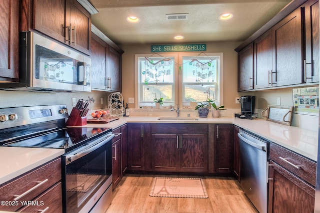310 S 12th St, Selah, WA 98942 - kitchen with appliances with stainless steel finishes, light wood-style flooring, light countertops, recessed lighting, and dark brown cabinets