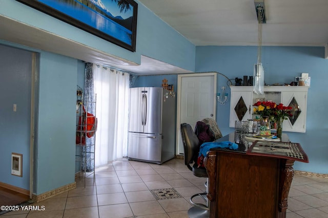 kitchen featuring freestanding refrigerator and light tile patterned flooring