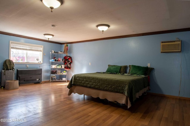 bedroom featuring baseboards, crown molding, and wood finished floors