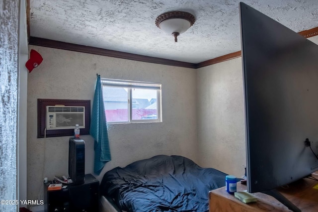 bedroom with crown molding, a wall mounted AC, a textured wall, and a textured ceiling