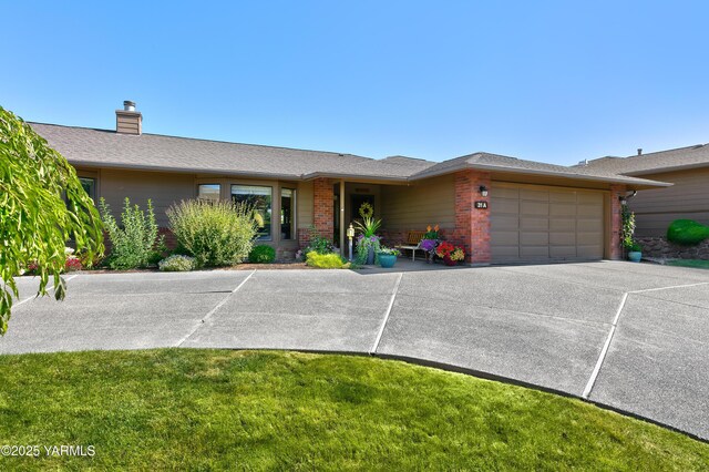 101 N 48th Ave Unit 31A, Yakima, WA 98908 - ranch-style home with a garage, brick siding, driveway, a chimney, and a front yard