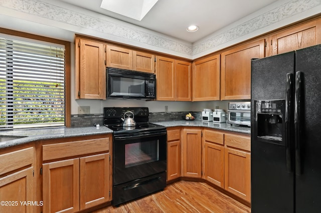 101 N 48th Ave Unit 31A, Yakima, WA 98908 - kitchen featuring black appliances, light wood-style floors, a skylight, recessed lighting, and brown cabinetry