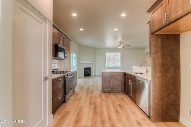 302 N 90th Ave, Yakima, WA 98908 - kitchen with stainless steel appliances, a fireplace, light wood-style floors, a ceiling fan, and recessed lighting