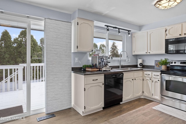 4704 W Prasch Ave, Yakima, WA 98908 - kitchen with a sink, visible vents, dark countertops, black appliances, and light wood-style floors