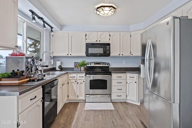 4704 W Prasch Ave, Yakima, WA 98908 - kitchen with light wood-style flooring, a sink, dark countertops, and black appliances