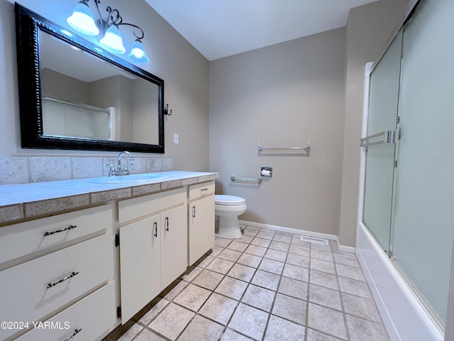 bathroom with enclosed tub / shower combo, toilet, vanity, baseboards, and tile patterned floors