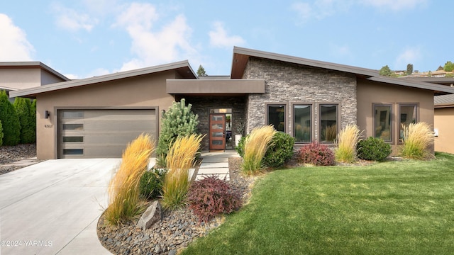 view of front of property with a garage, stone siding, concrete driveway, stucco siding, and a front yard