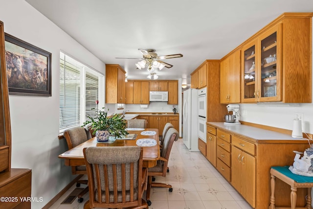 516 N Elm St, Toppenish, WA 98948 - kitchen featuring white appliances, ceiling fan, light flooring, brown cabinetry, and light countertops