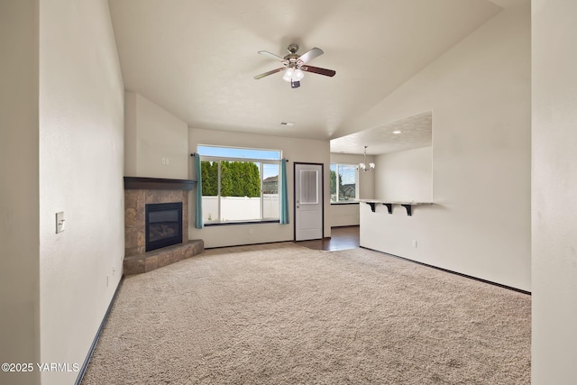 5901 Coolidge Rd, Yakima, WA 98903 - unfurnished living room with carpet floors, a tiled fireplace, ceiling fan, vaulted ceiling, and a chandelier