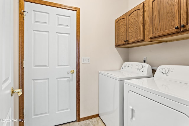 clothes washing area with cabinet space, light tile patterned floors, baseboards, and washing machine and clothes dryer