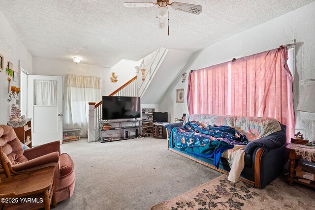 carpeted living area with a ceiling fan and a textured ceiling