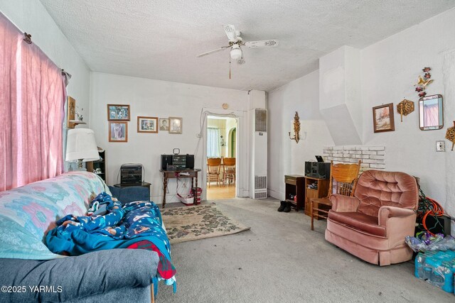 living room featuring ceiling fan, a textured ceiling, and carpet flooring