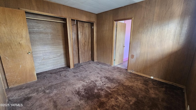 807 S 11th Ave, Yakima, WA 98908 - unfurnished bedroom with wooden walls, multiple closets, and carpet flooring